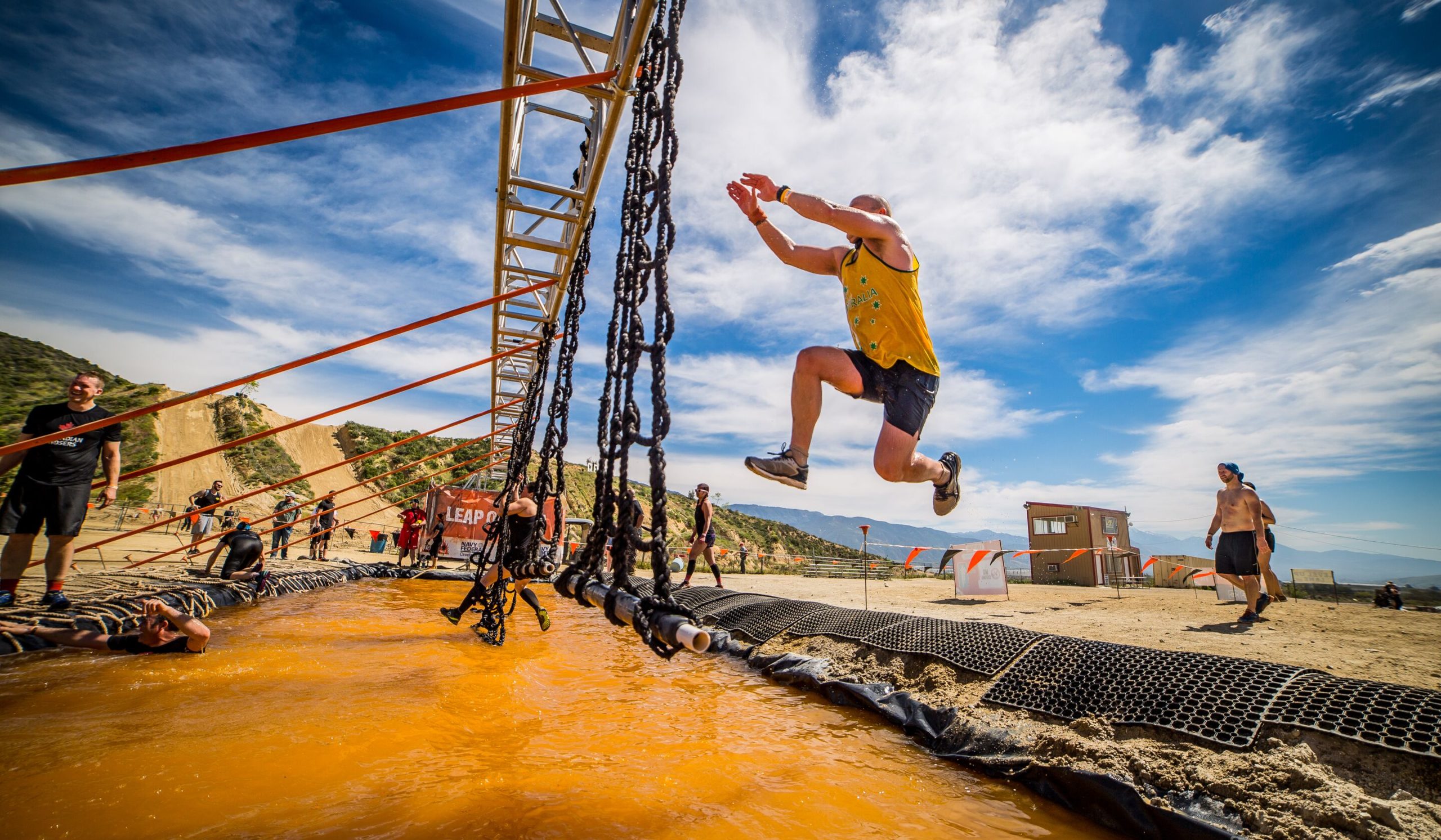 Participant jumping across water